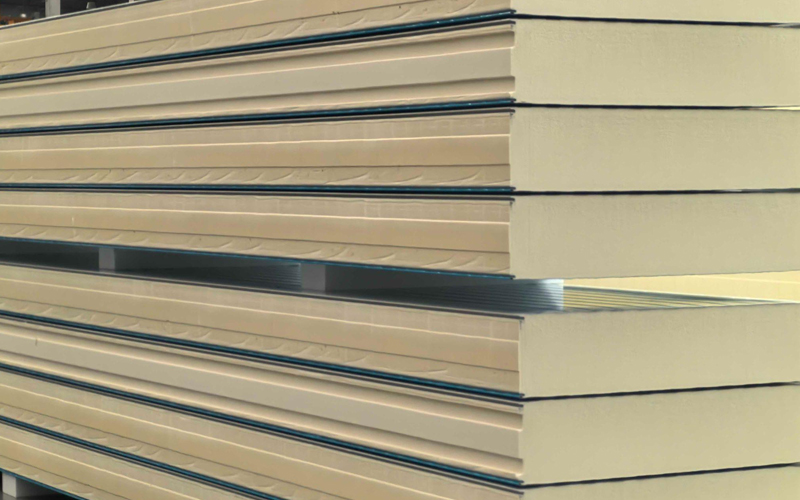 Cross-section of a PIR insulated panel revealing the dense polyisocyanurate foam core between metal facings.